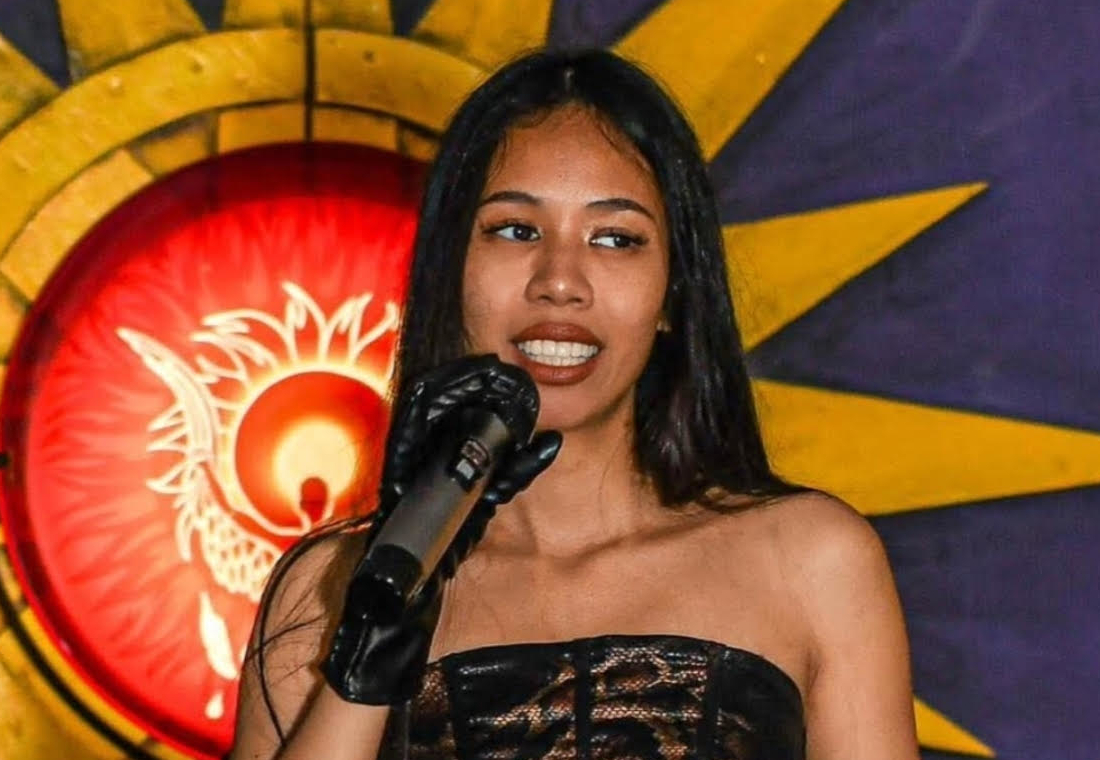 Alaiza Clark performing live on stage with a microphone